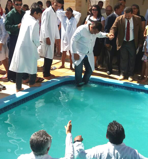 Duarte descendo às águas para o batismo, conduzido pelo pastor Severino