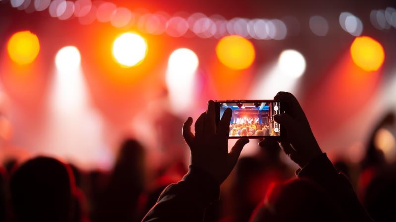 45e2eb_CONG_MATERIA_personcloseuprecordingvideowithsmartphoneconcert